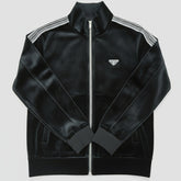 Black track jacket with white stripes on a light wooden surface